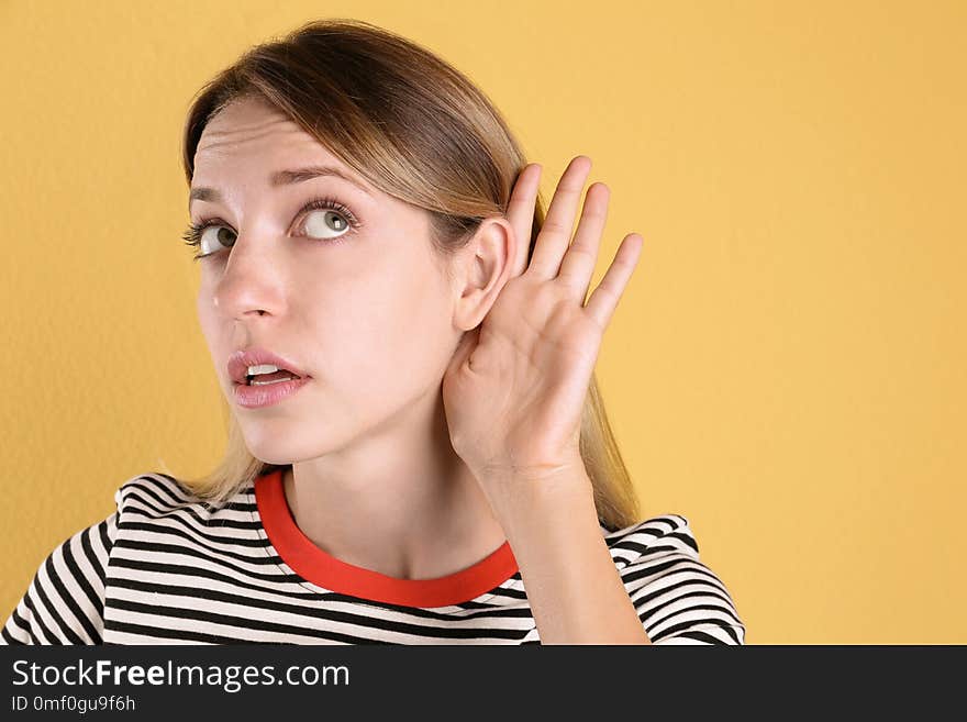 Young woman with hearing problem on color background