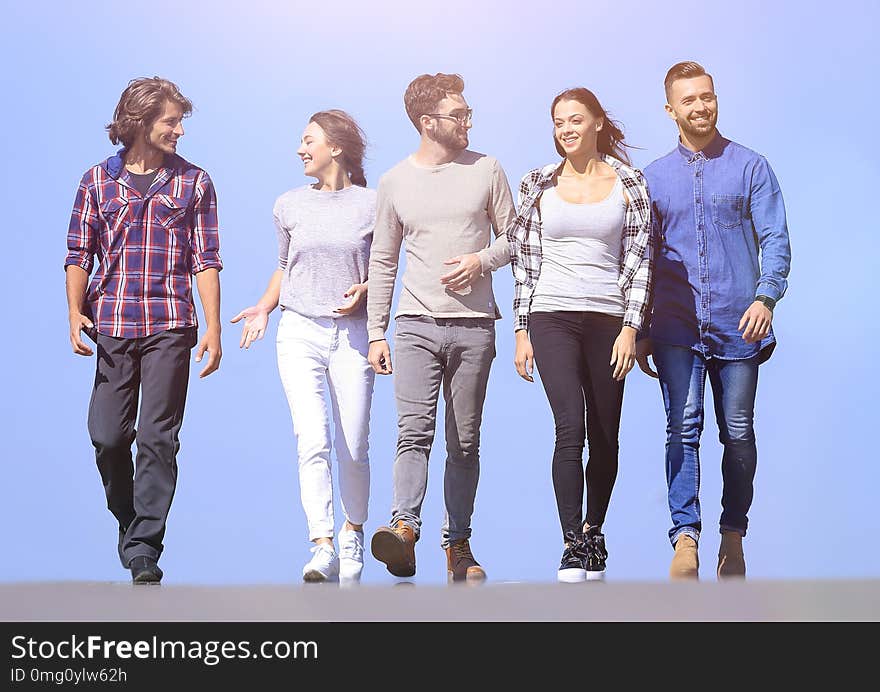 Team of young people walking along the road.outdoors