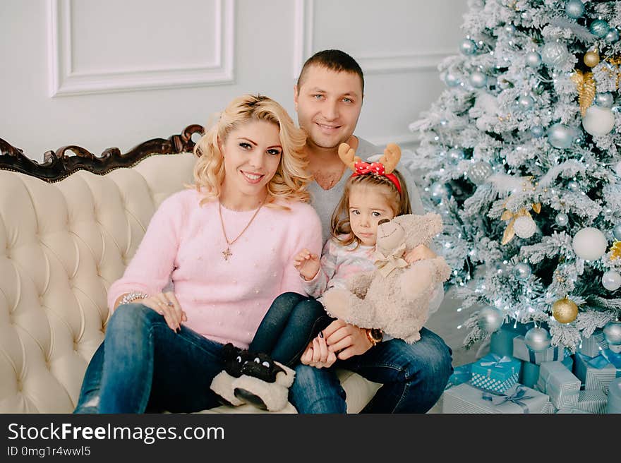 Portrait of young happy family near Christmas tree. Portrait of young happy family near Christmas tree