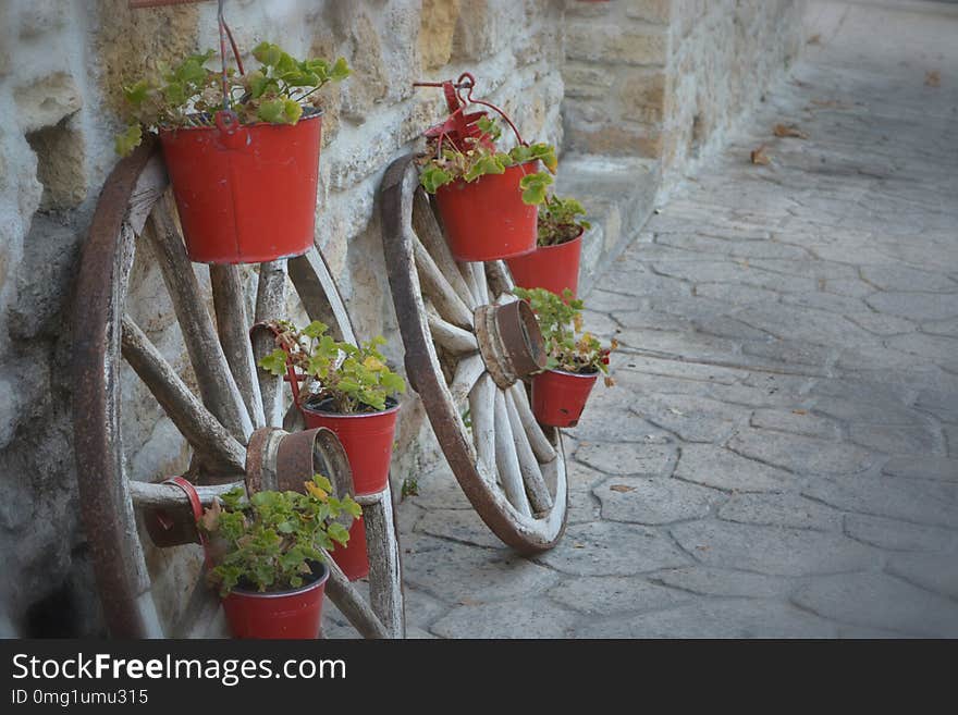 Wheels And Red Flowerpots In Afytos