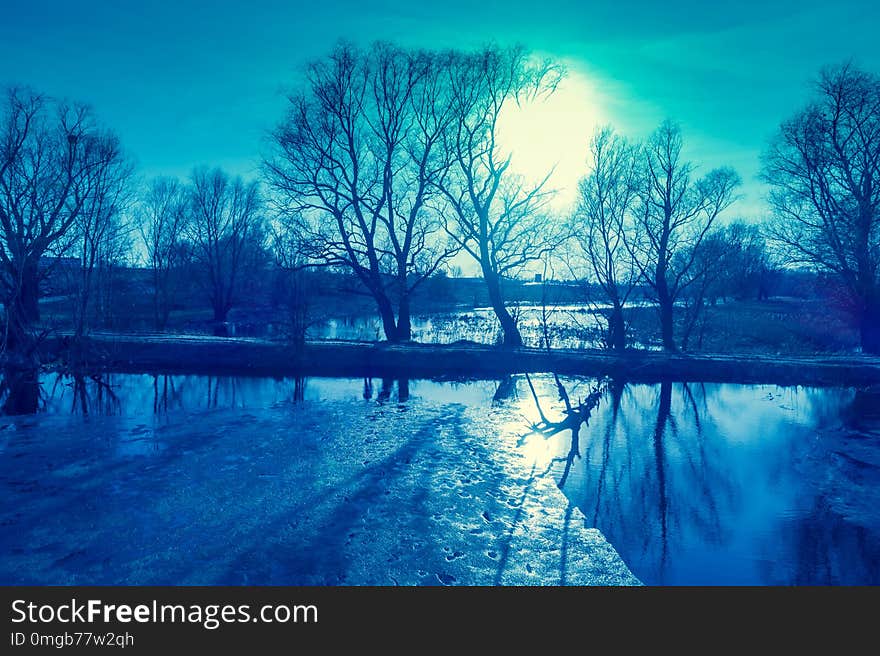 View of a river with floating ice in the evening in early spring. Rural landscape.