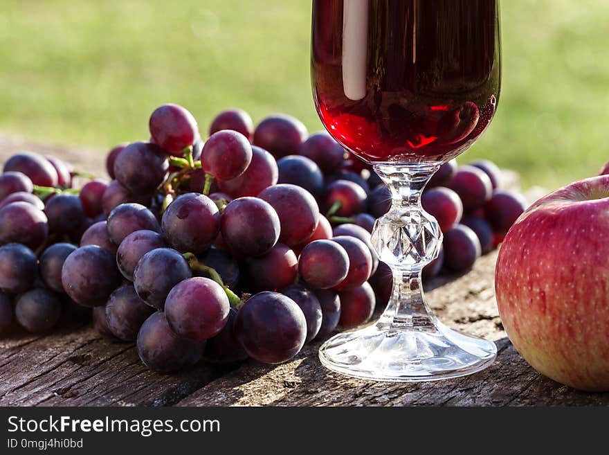 Red wine, grapes and apples on a wooden background. Red wine, grapes and apples on a wooden background.