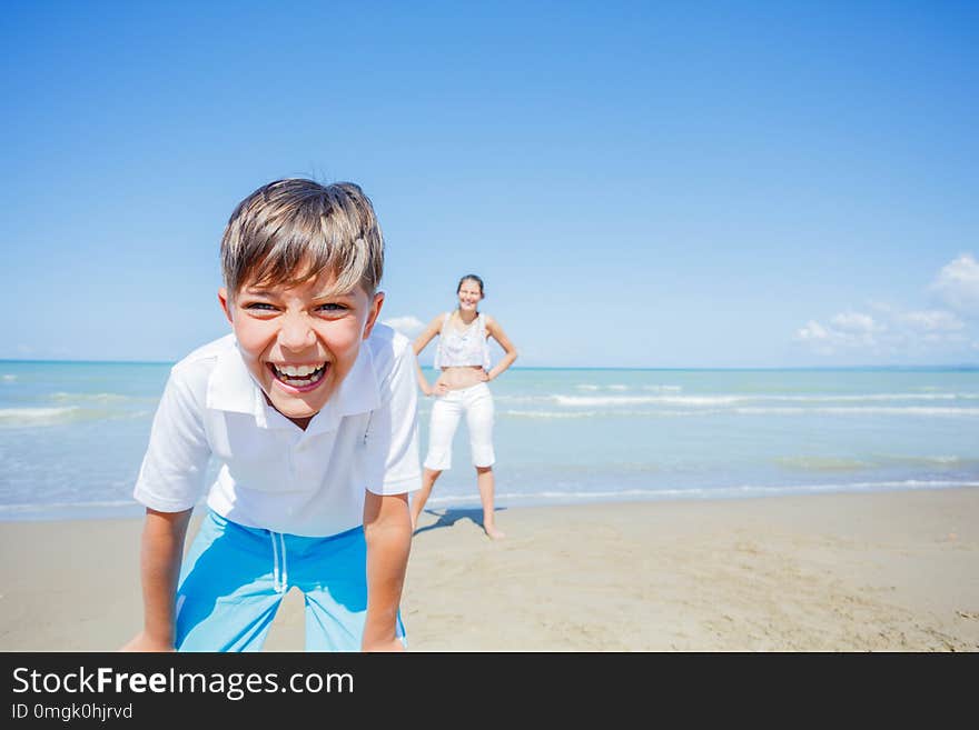 Portrait of Adorable boy with his sister boy with his sister on the beach on summer holidays. Children in nature with beautiful sea, sand and blue sky. Portrait of Adorable boy with his sister boy with his sister on the beach on summer holidays. Children in nature with beautiful sea, sand and blue sky.