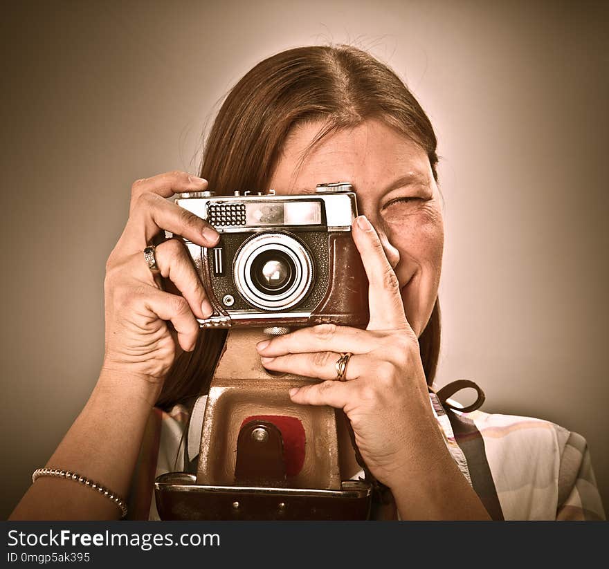 Woman with old camera on grey background