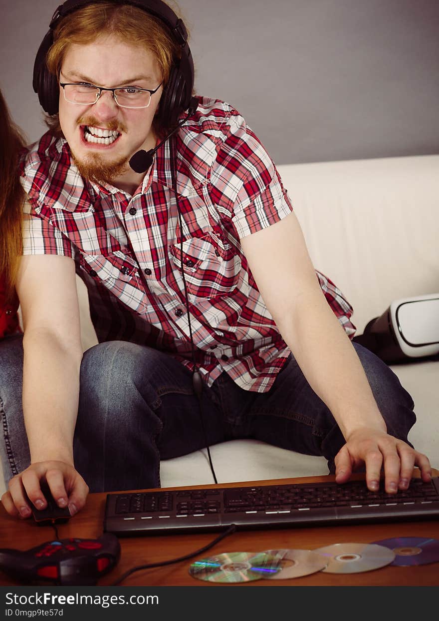 Nerd geek young adult man playing on the video console holding game pad. Gaming gamers concept. Nerd geek young adult man playing on the video console holding game pad. Gaming gamers concept.