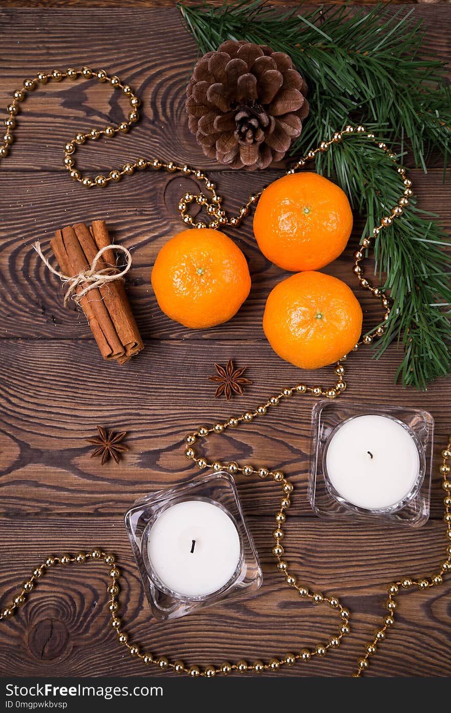 Christmas background - spruce branches with cones, mandarins cinnamon, star anise, Christmas decor. Flat lay, empty space.