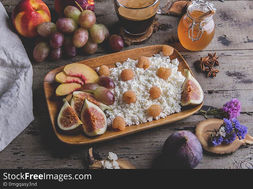 Homemade ricotta cheese , raspberries,figs , peach, honey. Healthy breakfast, coffee. on serving board over rustic wooden a