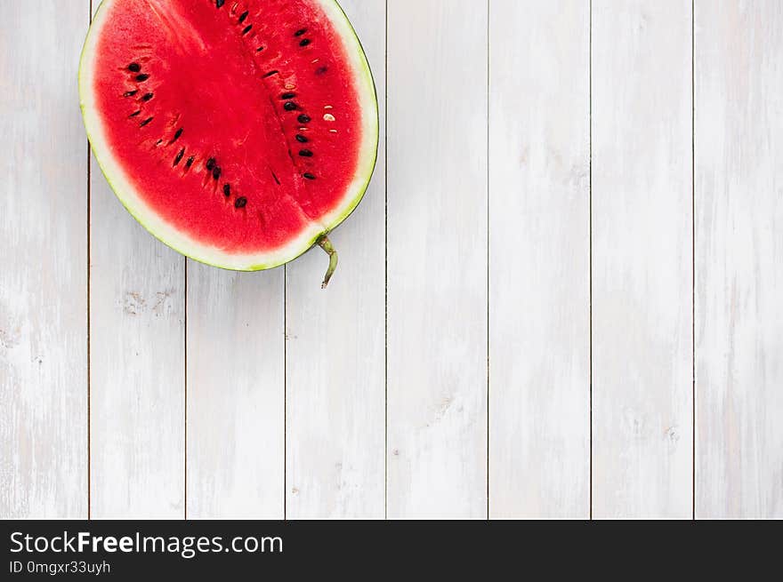 Watermelon on a light rustic wooden background top view. Juicy ripe watermelon, summer food background