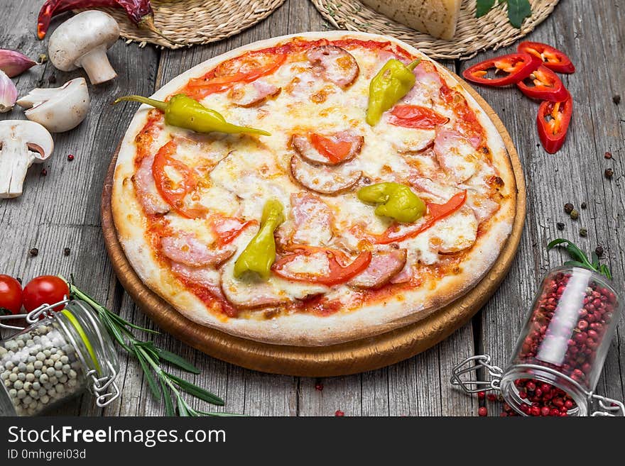 Pizza with tomatoes, mozzarella cheese, black olives and basil. Delicious italian pizza on wooden pizza board. Table top view. Pizza with tomatoes, mozzarella cheese, black olives and basil. Delicious italian pizza on wooden pizza board. Table top view