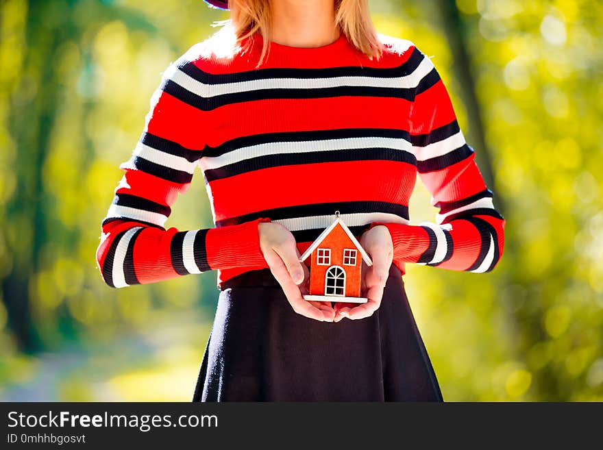 Girl holding a house toy in a park