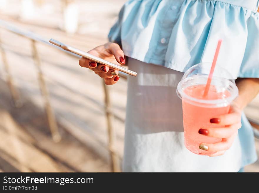 Beautiful girl student in glasses with cocktail in hand holding