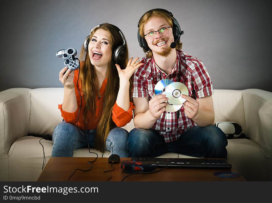 Happy couple enjoying leisure time by playing video games together. Studio shot. Happy couple enjoying leisure time by playing video games together. Studio shot