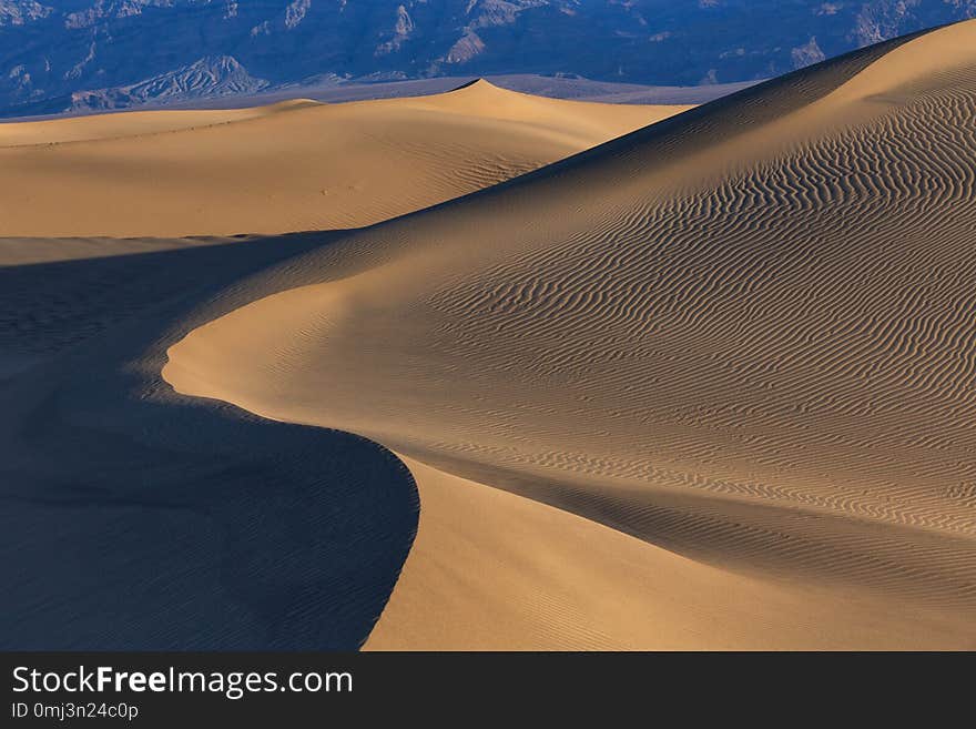 Waves of sand on top of the dunes at Sunrise in Mesquite flat dunes, Death Valley National Park, California, USA.