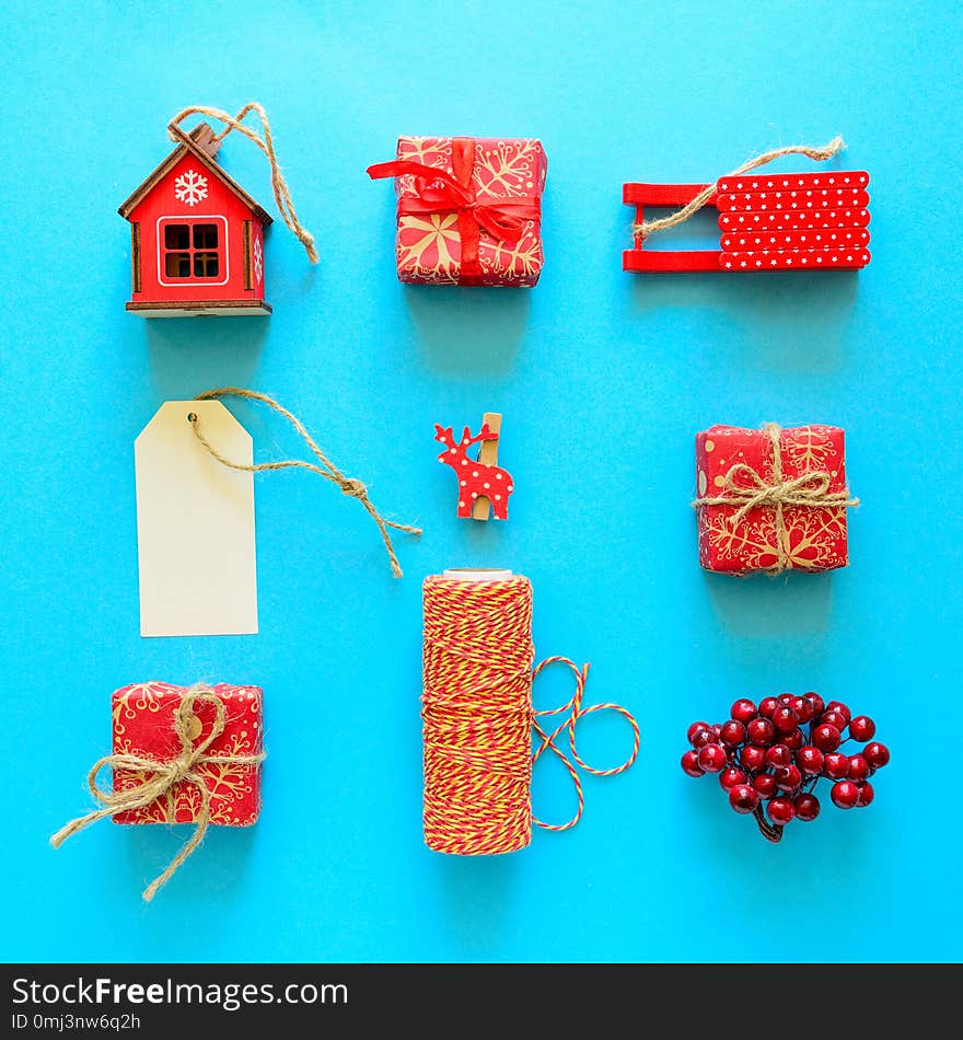 Red Christmas gift boxes and decorations on blue background. Flat lay. Top view