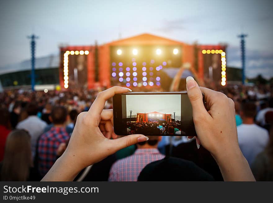 Smartphone in hands during outdoor rock concert