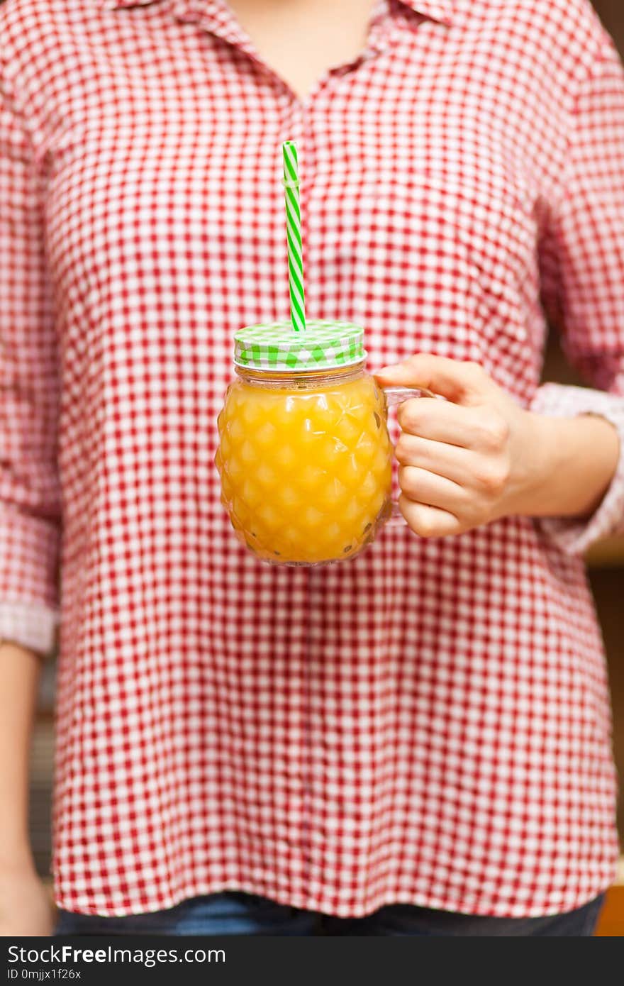 Girl In A Red Shirt Holding A Jar With Juice In The Form Of Pineapple