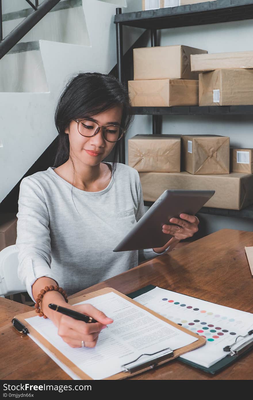 Self employed business woman working at her home office selling product on online shop