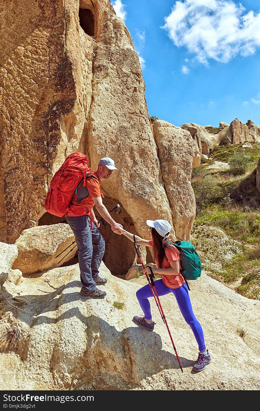 A helping hand for a girl high mountains in a hike. A helping hand for a girl high mountains in a hike.