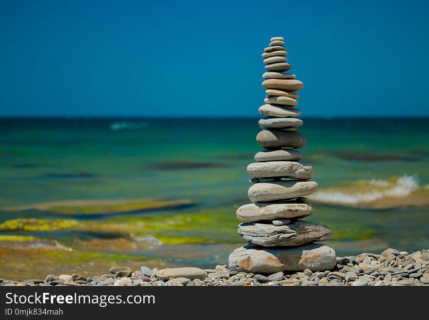 Stones balance, pebbles stack over blue sea. Blue sky on sunny adriatic coast in summer. Stones balance, pebbles stack over blue sea. Blue sky on sunny adriatic coast in summer.