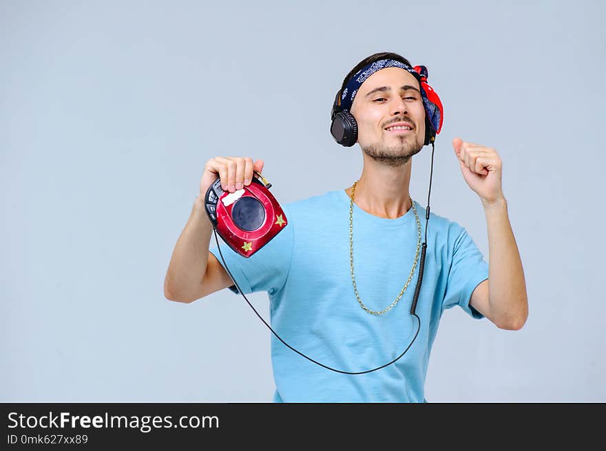 Fashionable bright man in headphones in retro style manifestation of emotions of joy, gestures with hands space for text.