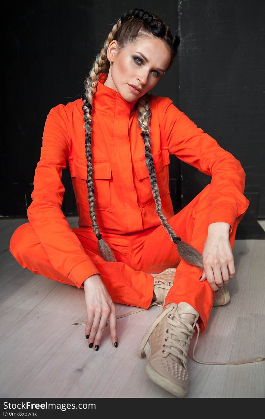 Female mechanic with braids in oranzhevom jumpsuit. Female mechanic with braids in oranzhevom jumpsuit