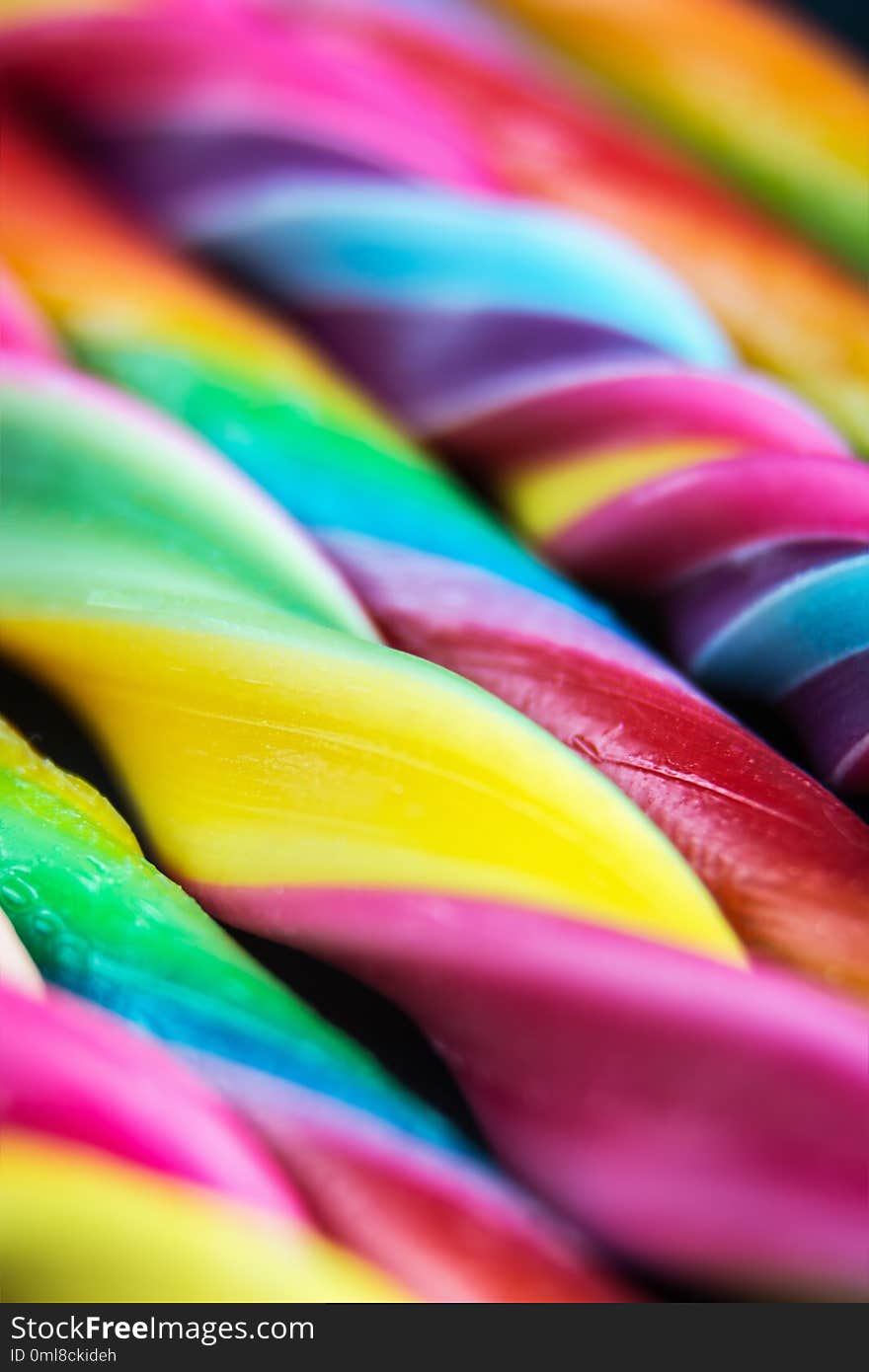 Candy canes of different colors of the rainbow. Soft focus, shallow depth of field