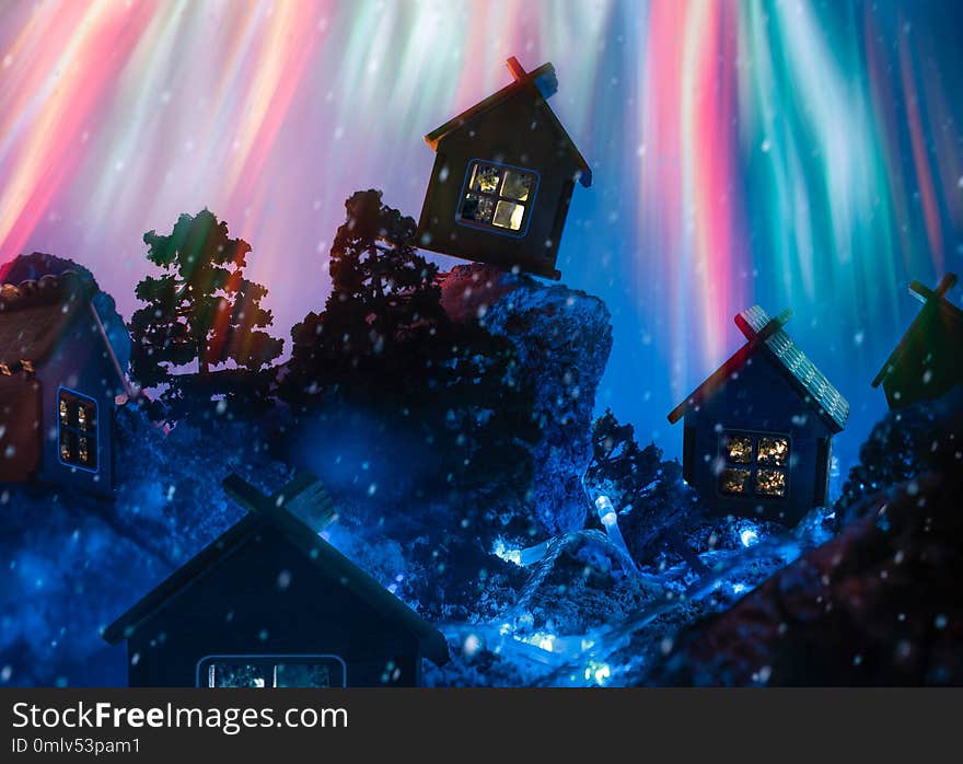 Night winter landscape with huts and fireworks