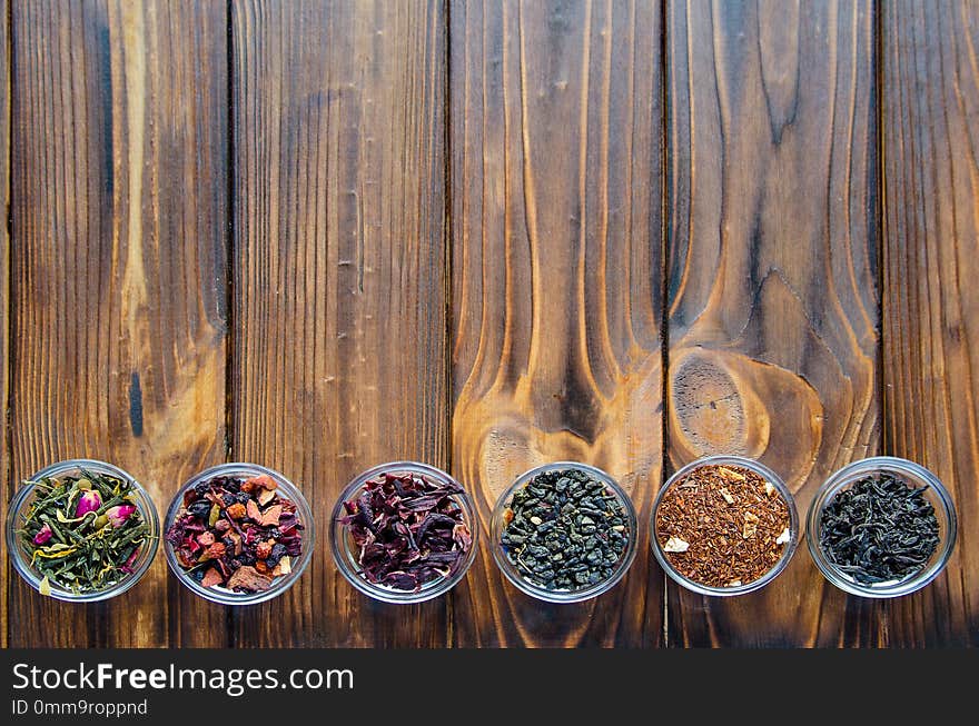 Selection of assorted teas in transparent little bowls on natural background