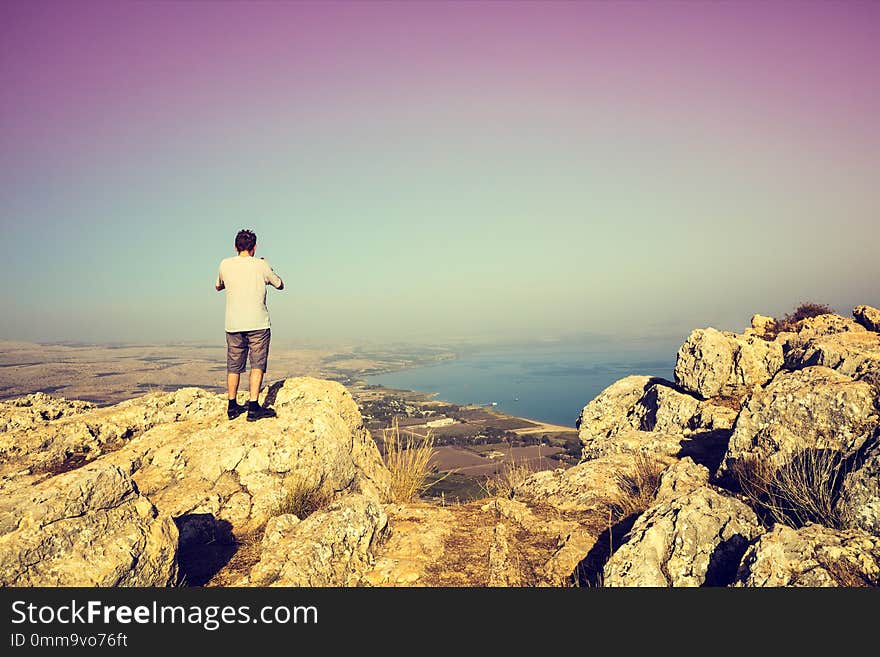 Man standing on Arbel cliff and looking at Galilee sea, Israel