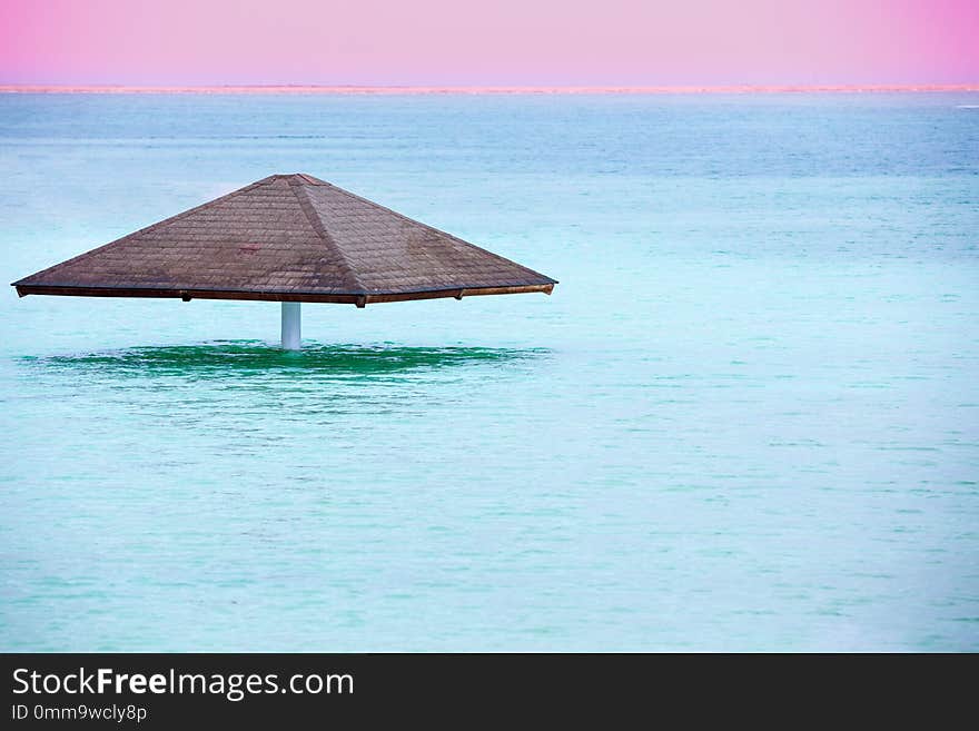 Sun umbrella in the water. Beautiful blue sea. The Dead Sea