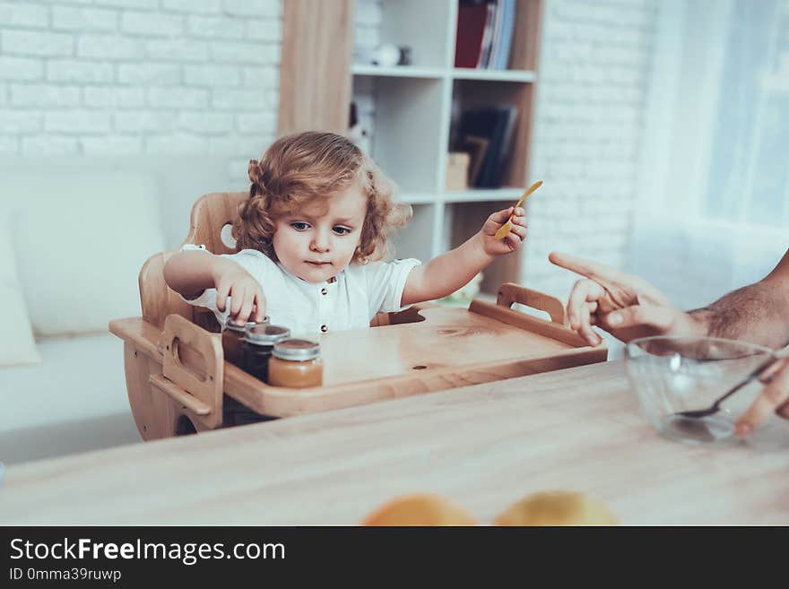 Man. Spends time. Son. Father of Boy. Engaged. Raising Child. Father Feeds his Son. Boy. Having Breakfast. Father. Sweet Boy. Delisious Food. Happy Together. Child on Chair. Leisure Time.