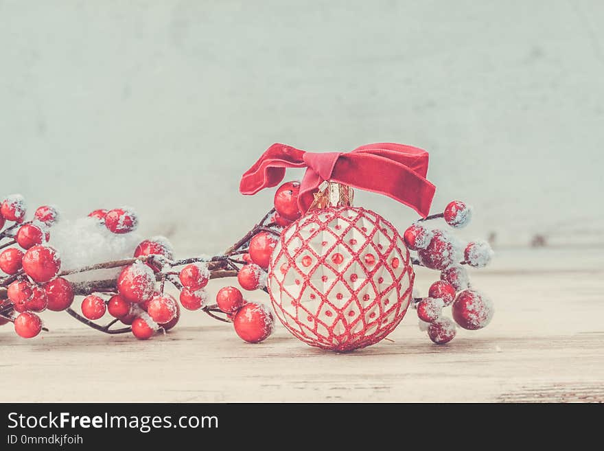 Red an white christmas - twig with berries on white wooden background, retro toned