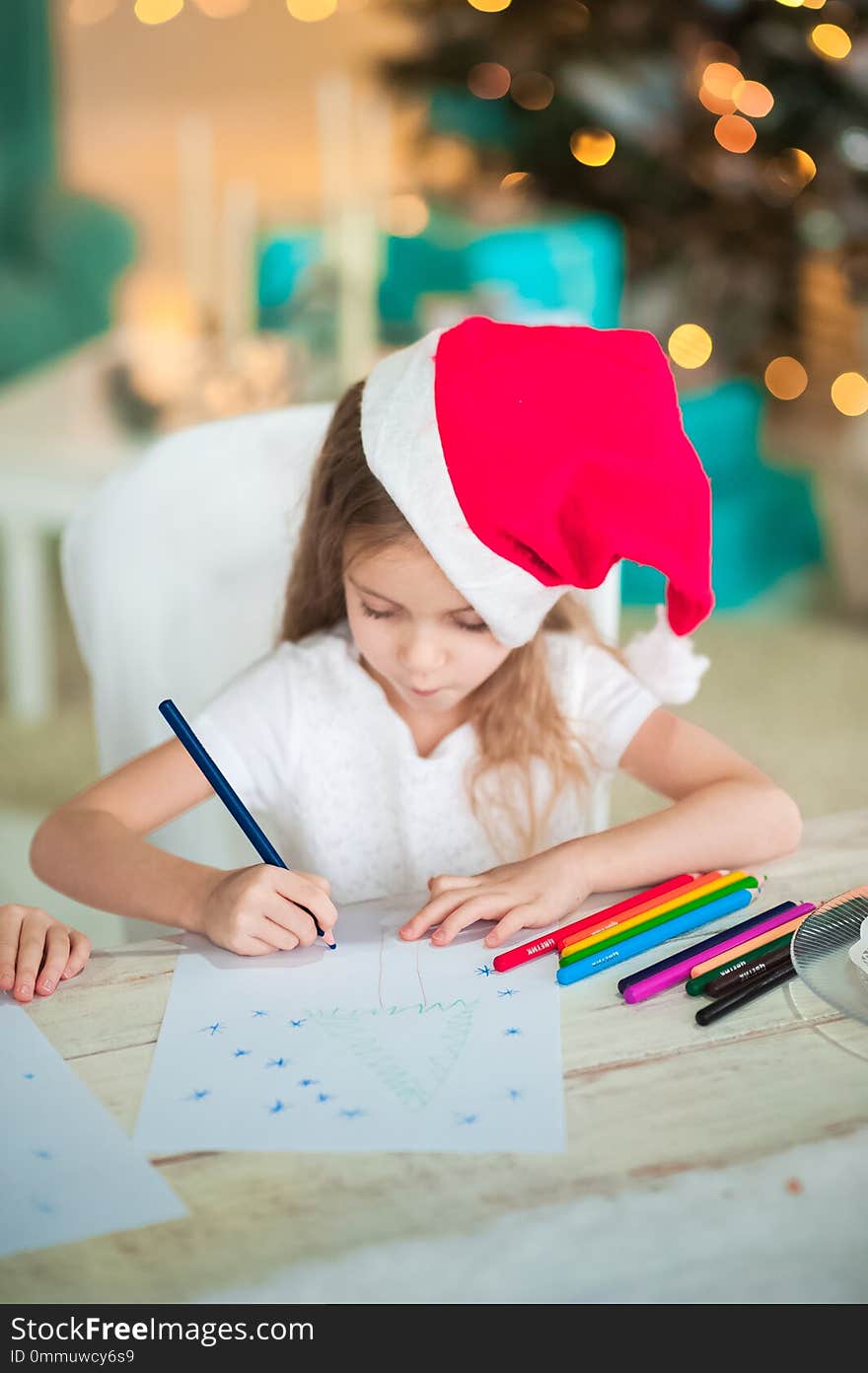 The girl writes a letter to Santa for the New Year.