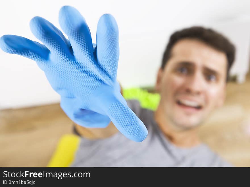 Frustrated young man holding cleaning equipment. Cleaning time