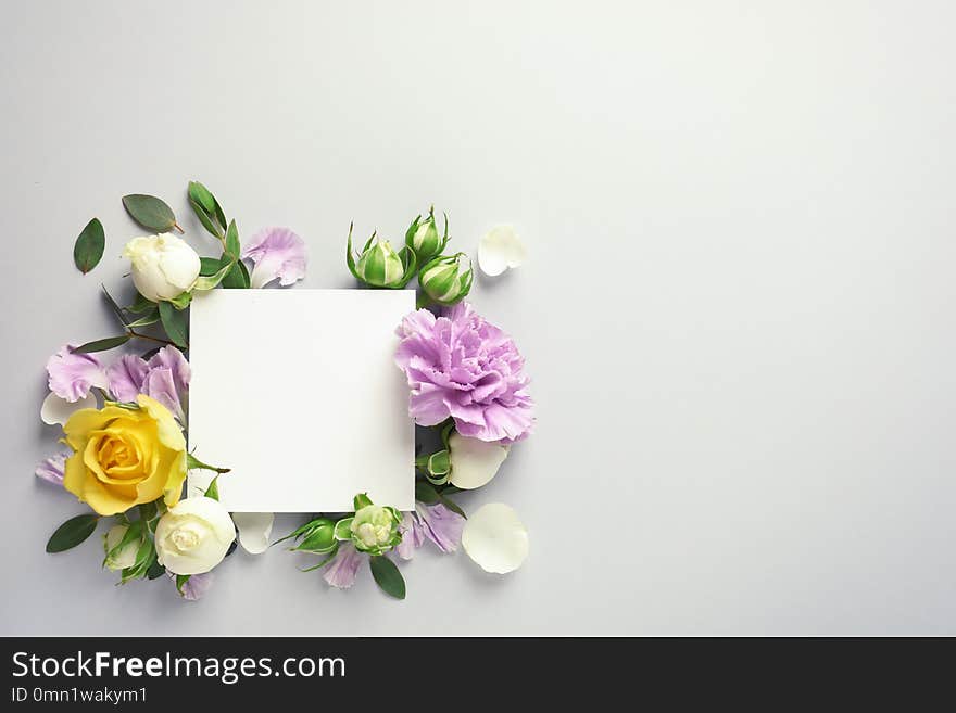 Flat lay composition with beautiful blooming flowers on grey background