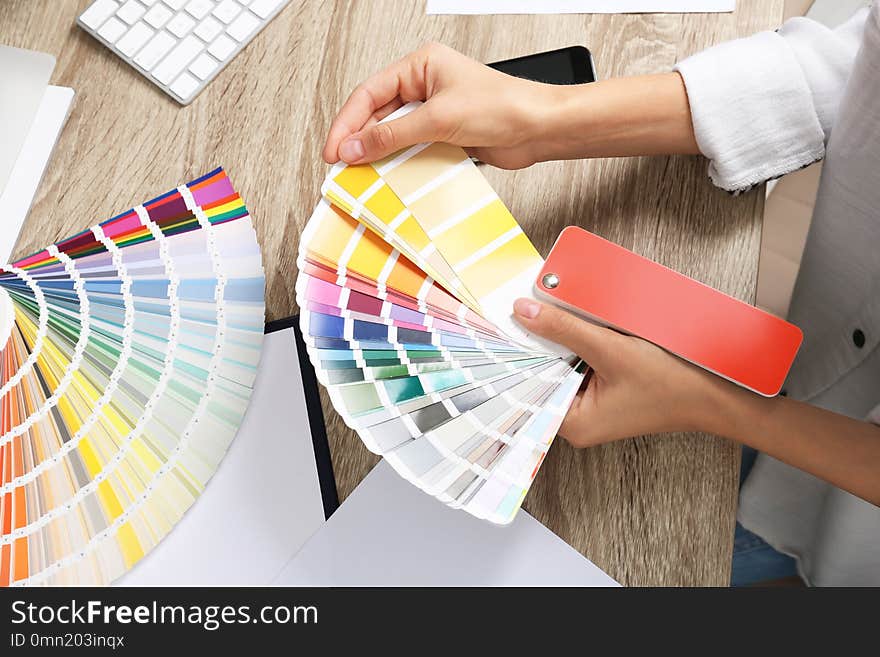 Woman with color palette samples at table, closeup