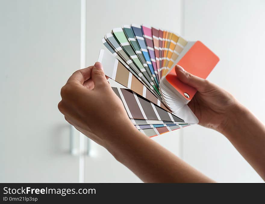 Female interior designer with color palette samples indoors, closeup