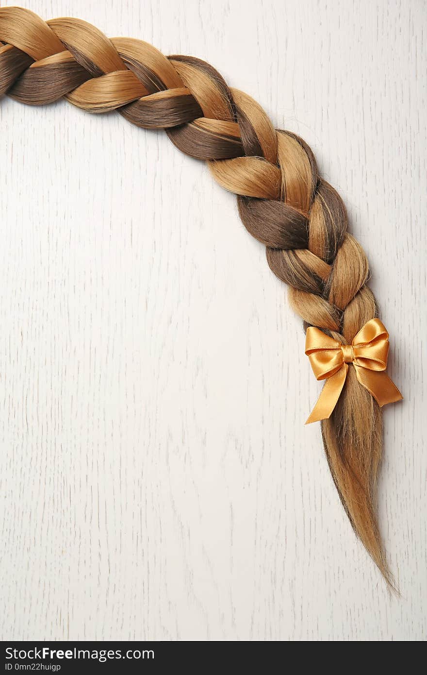 Braid and space for text on light background, top view. Healthy hair