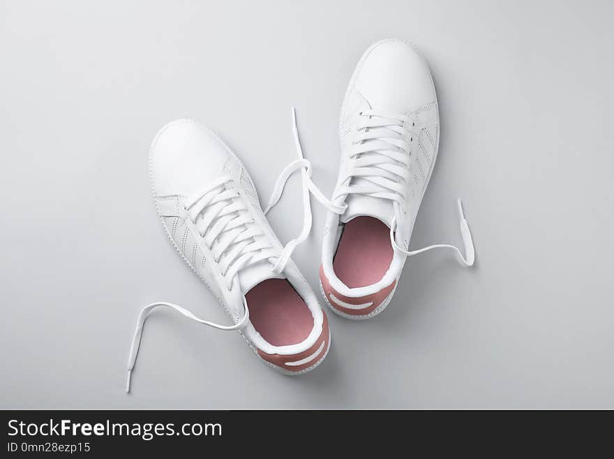 Pair of trendy sneakers on light background, flat lay