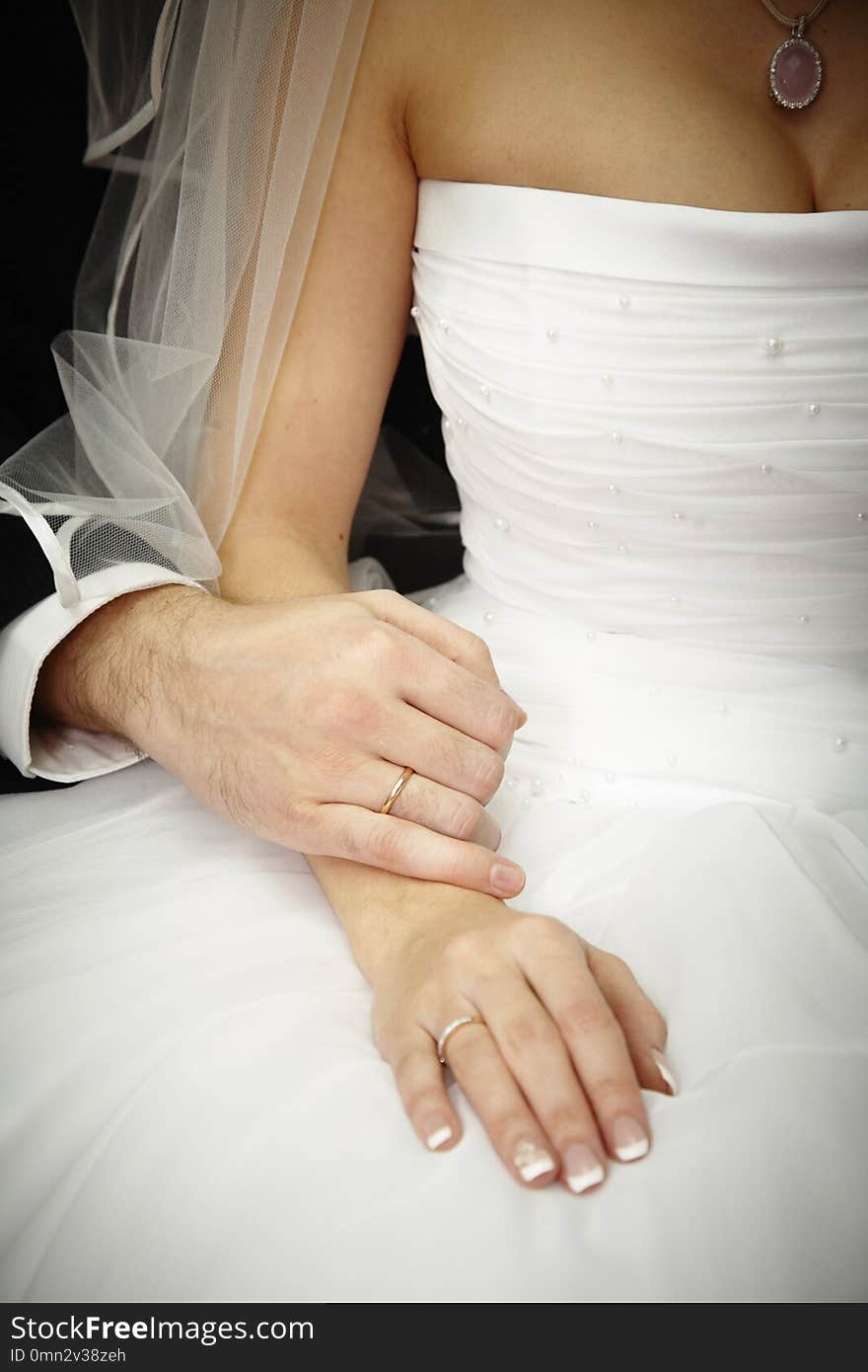 Hands of new lyweds with wedding rings near a bouquet. Hands of new lyweds with wedding rings near a bouquet