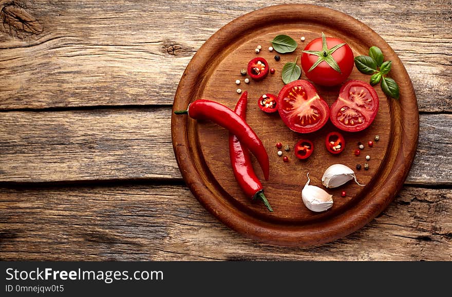 Fresh tomatoes, basil, pepper on wooden desk background. Top view