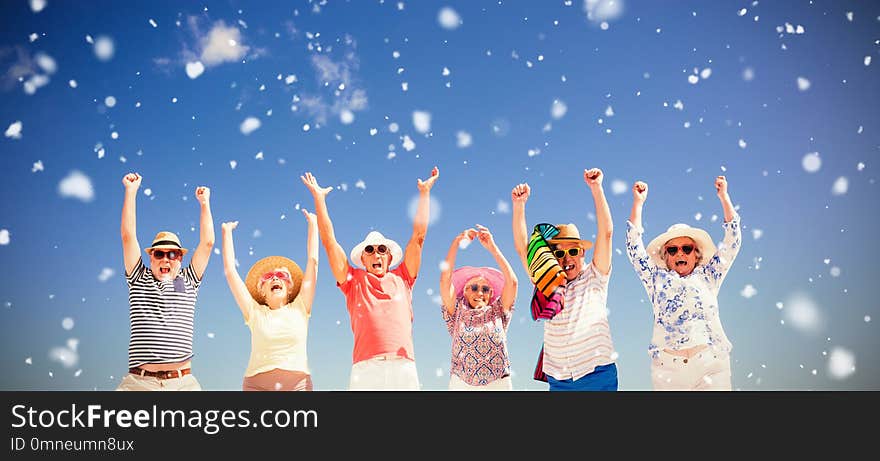 Snow falling against happy senior friends jumping. Snow falling against happy senior friends jumping