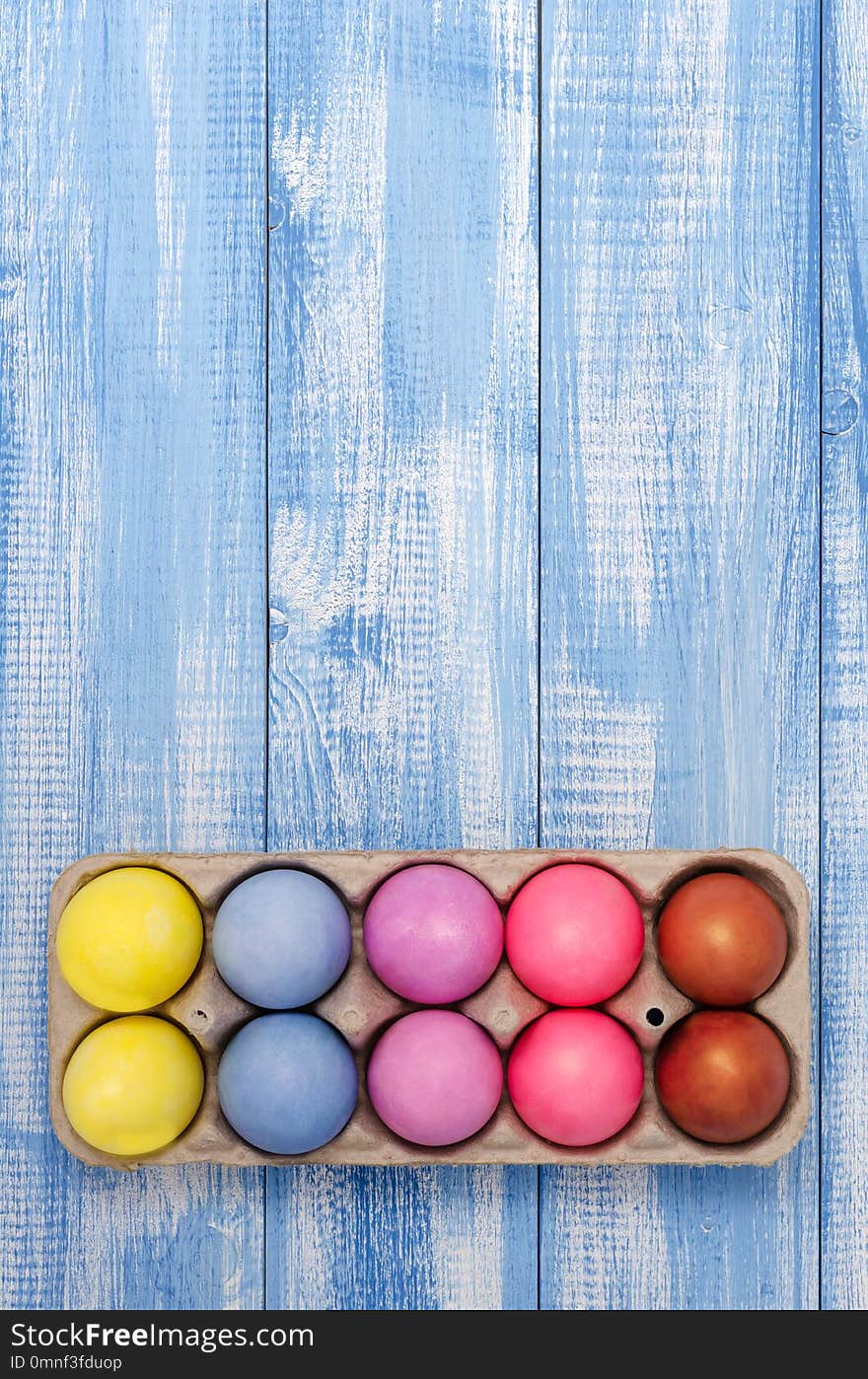 Easter eggs colored chicken on the colored, blue, wooden, background closeup. Easter eggs colored chicken on the colored, blue, wooden, background closeup