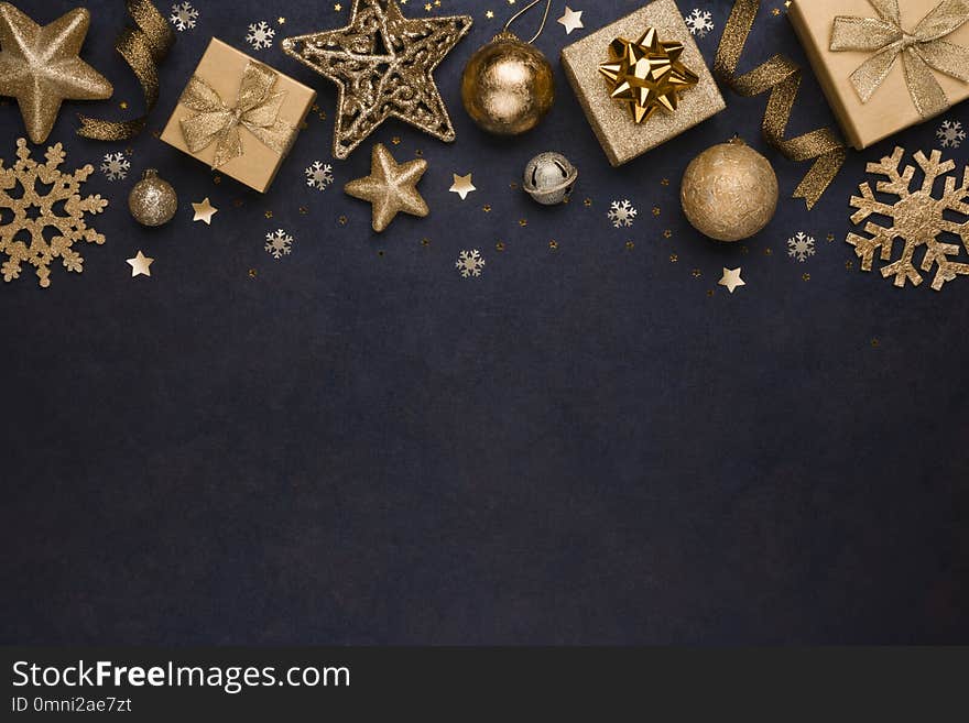 Golden snowflakes, gifts, christmas balls and stars on dark background.