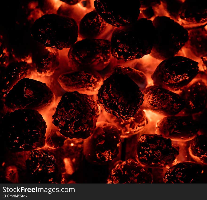 Flaming hot charcoal briquettes in detail. BBQ grill texture, food background