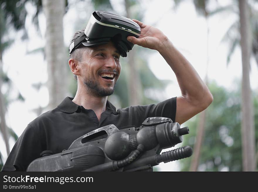 Man in virtual reality headset playing video game among palm trees. Man in virtual reality headset playing video game among palm trees