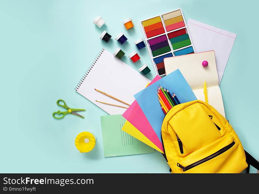 School stationary sets and knapsack on blue background.