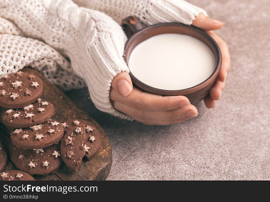 Female Hands Are Holding Cup Of Warm Milk, Chocolate Cookies On