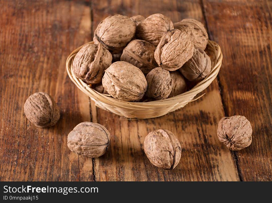 Walnuts in retro bowl and spilled on wooden desk