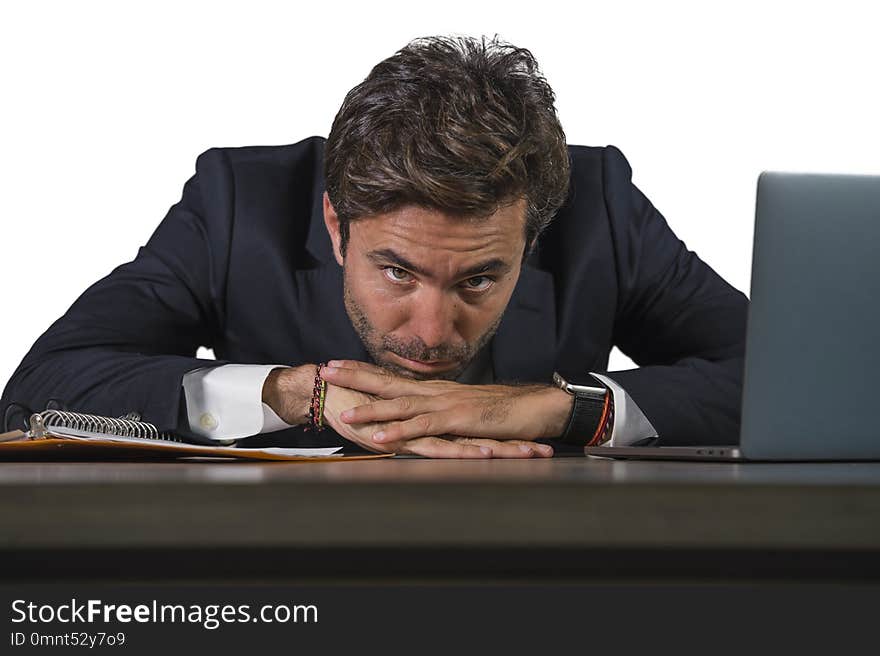 Young sad and depressed business man working overwhelmed and frustrated on laptop computer office desk feeling upset and stressed